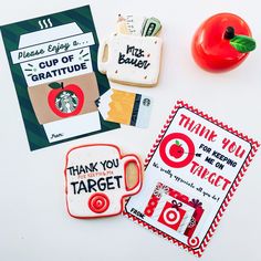 some cookies and cards on a table with a red pepper next to them, including a cup of gratitue