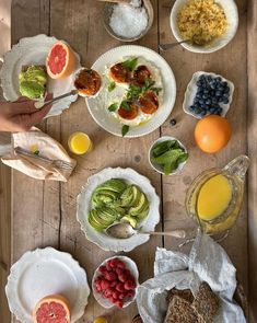 a wooden table topped with plates and bowls filled with different types of food on top of it