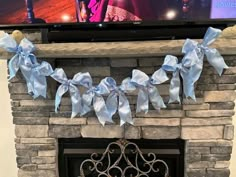 a fireplace decorated with blue ribbon and bows