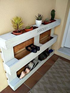 shoe rack made out of pallets with planters on top and shoes in the bottom