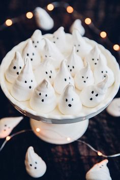 a white plate topped with marshmallows on top of a table next to candles