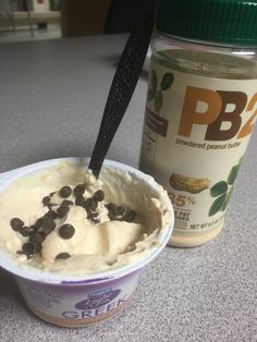 a bowl of ice cream with chocolate chips on top and a jar of peanut butter