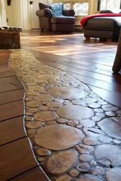 a wood floor with stones on it and a couch in the background