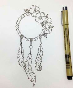 a drawing of a dream catcher with flowers on it and a pen next to it