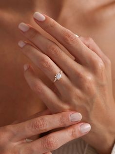 a woman's hand with a diamond ring on it