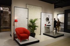 a man standing next to a red chair in a room filled with mirrors and furniture