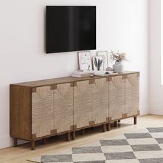 a tv mounted on the wall above a wooden cabinet in a room with white walls