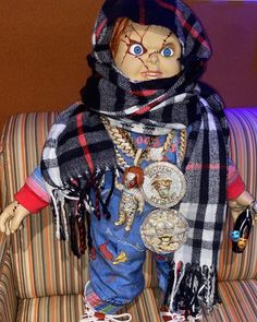 a creepy doll is sitting on a couch with a scarf around it's neck