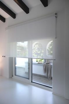 an empty room with sliding glass doors and white walls