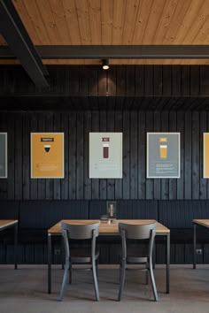 three wooden tables and chairs in a room with wood paneling on the wall behind them