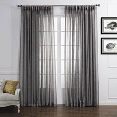 a living room filled with furniture and a window covered in gray drapes, next to a lamp