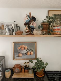 a kitchen counter with pots and pans on top of it, next to a painting