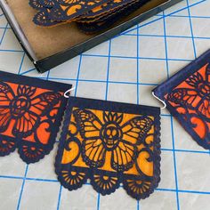 three orange and blue paper cut outs sitting on top of a table