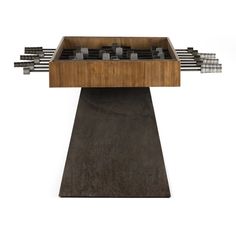 a wooden table topped with lots of metal objects on top of a cement slab next to a white wall