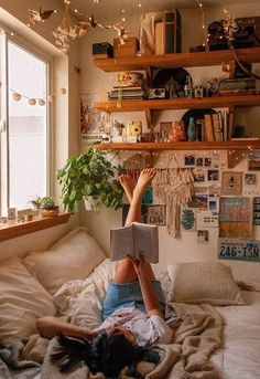 a woman laying on top of a bed reading a book