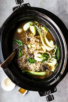 an overhead view of a bowl of soup with noodles and vegetables