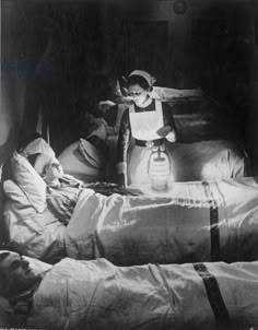 an old black and white photo of a child in bed