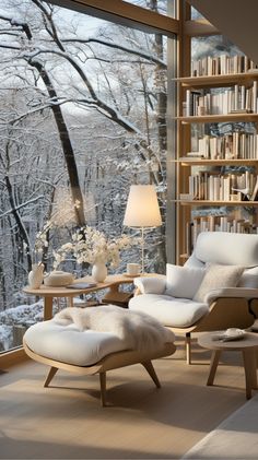 a living room filled with furniture and a large window covered in snow next to a forest