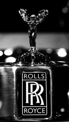 rolls royce logo on the hood ornament of a rolls royce car in black and white