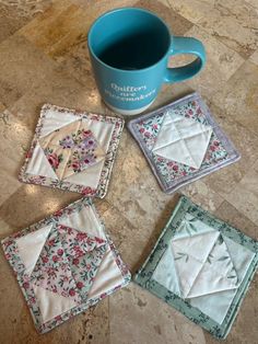 four quilted coasters and a coffee mug on the floor