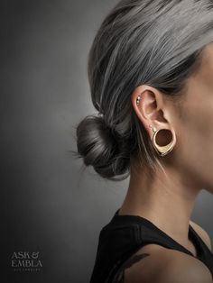 a woman with grey hair wearing an earring