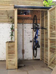 a bicycle is parked in the corner of a shed