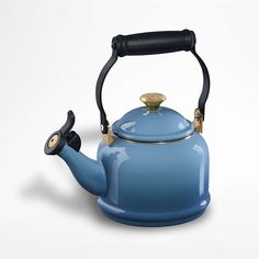 a blue tea kettle with a black handle