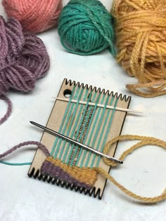 several skeins of yarn sitting on top of a table next to knitting needles