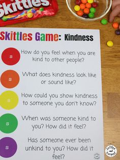 a child's hands holding a candy bar game on top of a wooden table