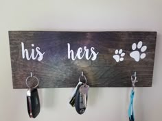 a wooden sign with key hooks hanging from it's sides that says, his hers