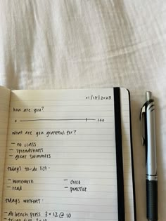 an open notebook with writing on it next to a pen