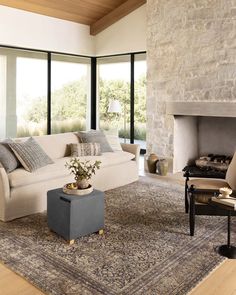 a living room filled with furniture and a fire place in front of a stone fireplace