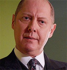 a man in a suit and tie looking at the camera with an intense look on his face