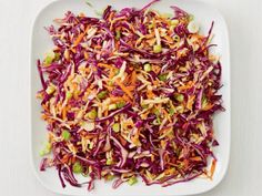 a white plate topped with coleslaw slaw and carrots on top of a table