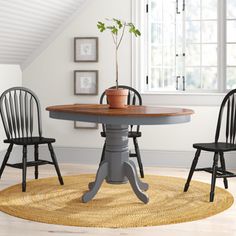 three chairs around a table with a potted plant on it