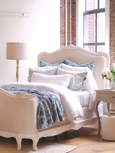 a white bed sitting in a bedroom next to a window