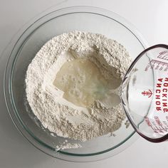 a glass bowl filled with flour next to a measuring cup