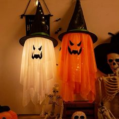 three halloween decorations on a table with skeletons and pumpkins in front of the lights