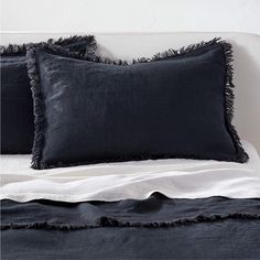 a bed with two black pillows on top of it