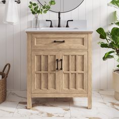 a bathroom with a sink, mirror and potted plant