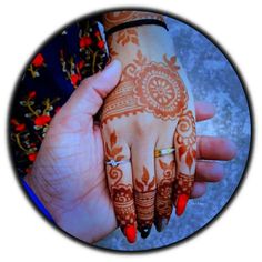 a woman's hand with henna tattoos on it