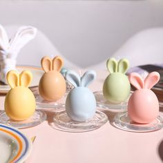 four small plastic bunny ears sitting on top of each other next to plates and napkins