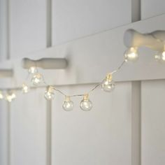 some lights are hanging on the side of a white wall and there is no image here to provide a caption for