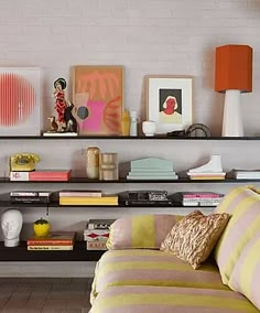 a living room filled with lots of furniture and books on top of a wooden shelf