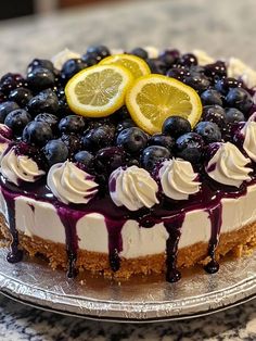 a cake with blueberries and lemon slices on top is sitting on a countertop