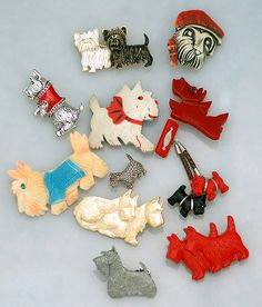 a collection of dog brooches on a blue surface with white and red accents