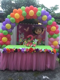 an outdoor birthday party with balloons, flowers and decorations on the outside table cloths