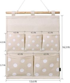 the hanging organizer is made from canvas and has four pockets with white polka dots on it