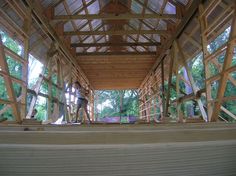 a man standing on top of a wooden floor next to a building with wood framing