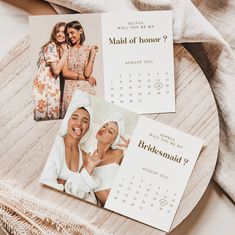 two calendars with pictures of women on them sitting next to a blanket and towel